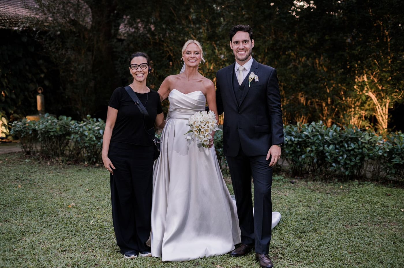 Noivos ao lado da cerimonialista da Rito Eventos no jardim, depois da cerimônia de casamento