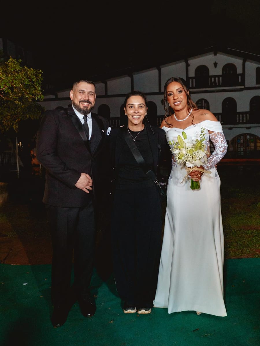Casal de noivos com a cerimonialista da Rito Eventos na entrada do casamento à noite